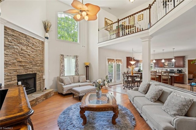 6065 Providence Church Rd, Winston-Salem, NC 27105 - living room with light wood finished floors, a high ceiling, a stone fireplace, and a ceiling fan
