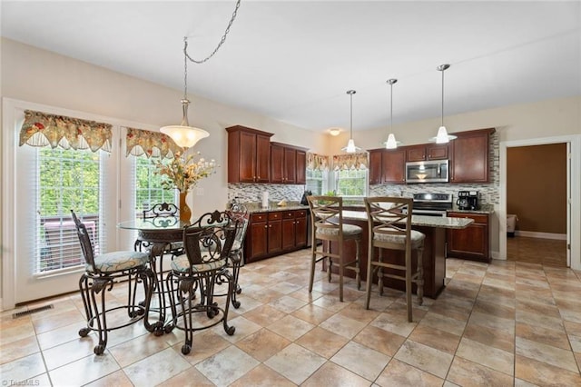 6065 Providence Church Rd, Winston-Salem, NC 27105 - kitchen with appliances with stainless steel finishes, a center island, visible vents, and backsplash