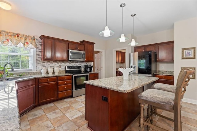 6065 Providence Church Rd, Winston-Salem, NC 27105 - kitchen featuring a sink, stainless steel appliances, a kitchen island, light stone countertops, and hanging light fixtures