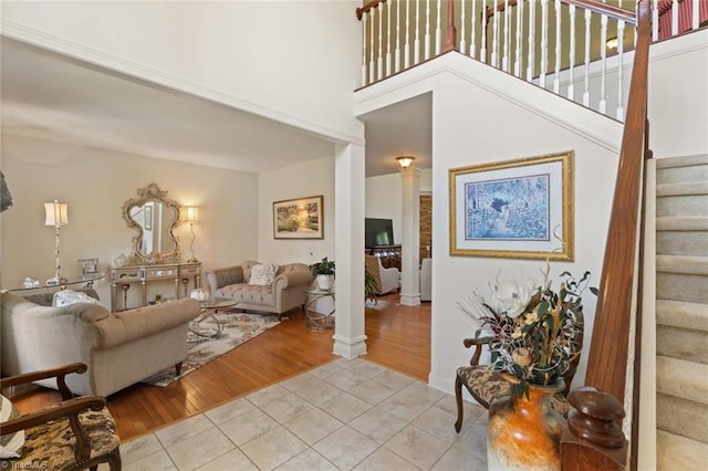 6065 Providence Church Rd, Winston-Salem, NC 27105 - living area featuring a high ceiling, ornate columns, light tile patterned floors, stairs, and baseboards