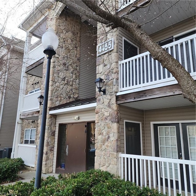 view of home's exterior featuring stone siding and central AC unit