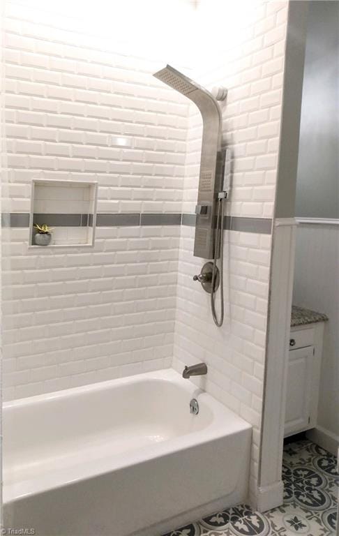 bathroom with vanity, tile patterned flooring, and tiled shower / bath