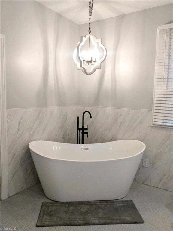 bathroom featuring an inviting chandelier and tile walls