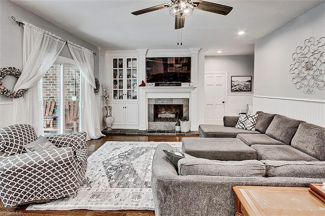 living room with dark hardwood / wood-style flooring, a fireplace, and ceiling fan