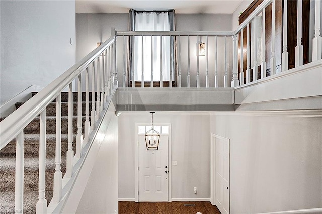 stairs featuring hardwood / wood-style floors and a chandelier