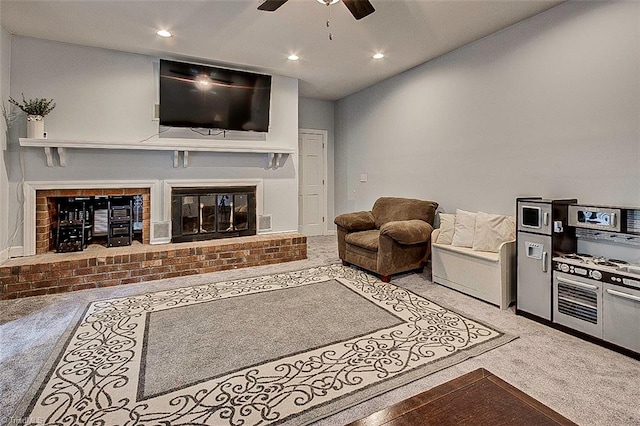 living room featuring light carpet, a brick fireplace, and ceiling fan