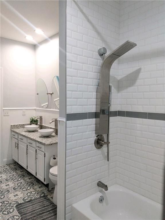 full bathroom featuring tiled shower / bath combo, vanity, tile patterned flooring, and toilet