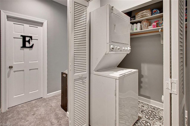 laundry area featuring stacked washer and clothes dryer and light tile patterned floors