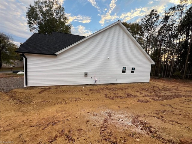 view of home's exterior with roof with shingles