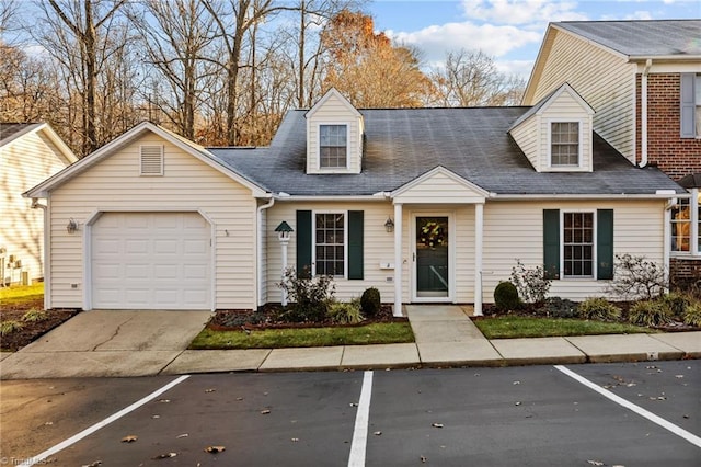 cape cod home featuring a garage