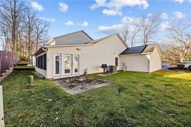 rear view of property featuring cooling unit, a yard, and a patio