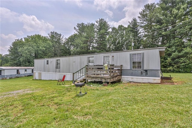 1105 Cabana Ln, East Bend, NC 27018 - back of house with a deck, view of wooded area, and a yard