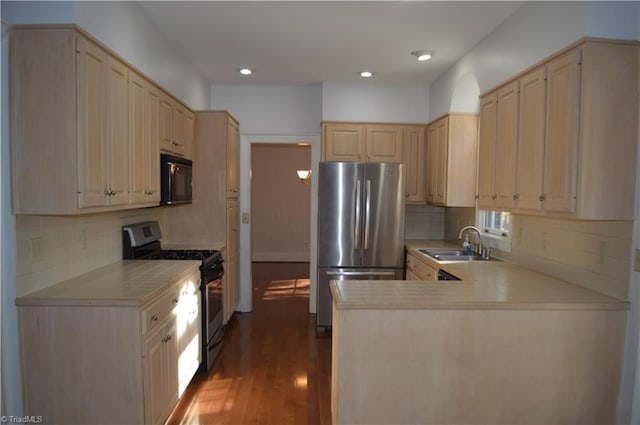 kitchen with stainless steel appliances, sink, kitchen peninsula, tasteful backsplash, and dark hardwood / wood-style flooring