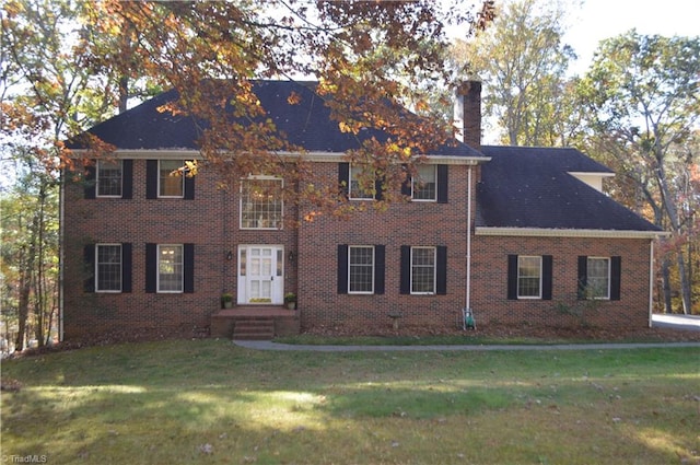 colonial house featuring a front lawn