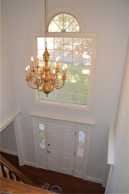 foyer entrance featuring a chandelier and dark hardwood / wood-style floors