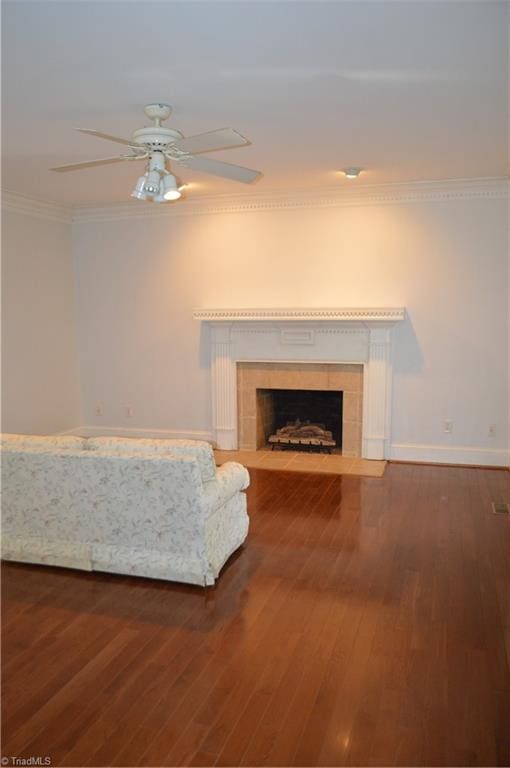 interior space with a fireplace, wood-type flooring, crown molding, and ceiling fan