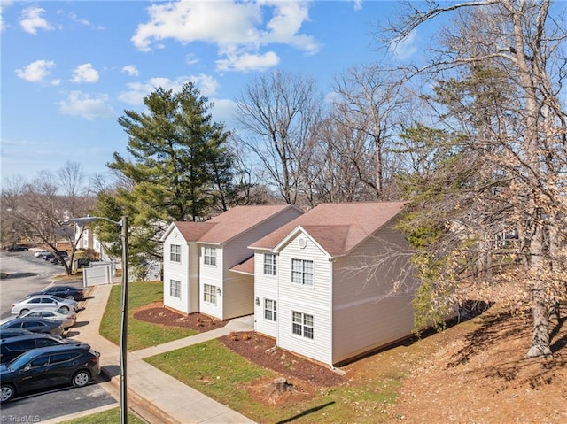 view of front of home featuring uncovered parking and a front lawn