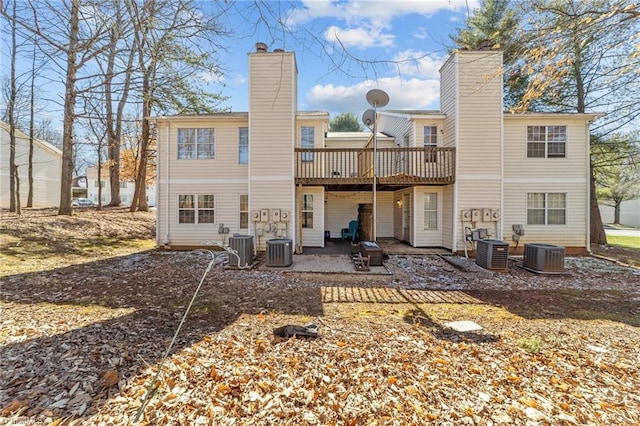 back of property with a chimney, central AC, and a patio