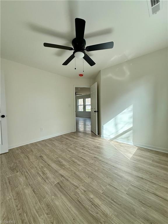 unfurnished room with ceiling fan and light hardwood / wood-style flooring