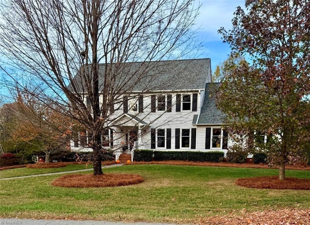 colonial-style house featuring a front yard