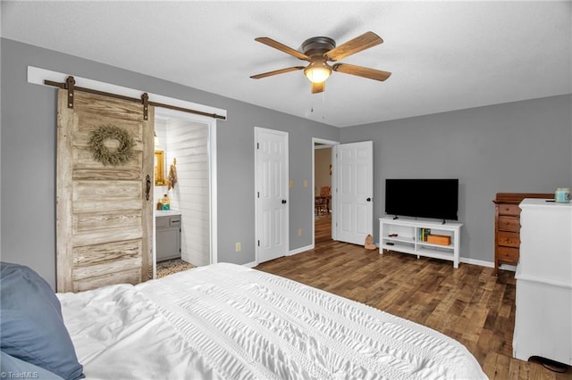 3809 Evergreen Dr, Trinity, NC 27370 - bedroom featuring wood finished floors, a barn door, ensuite bath, and a ceiling fan
