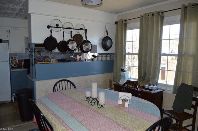 dining area featuring plenty of natural light and crown molding