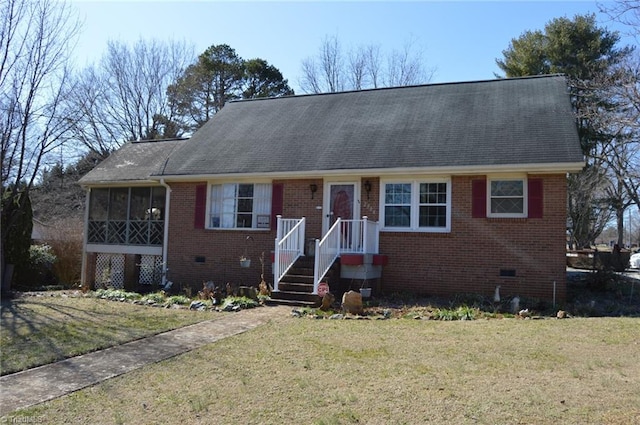 view of front of house featuring crawl space, a sunroom, a front lawn, and brick siding