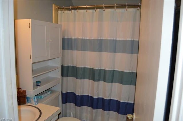 bathroom with toilet, curtained shower, and vanity