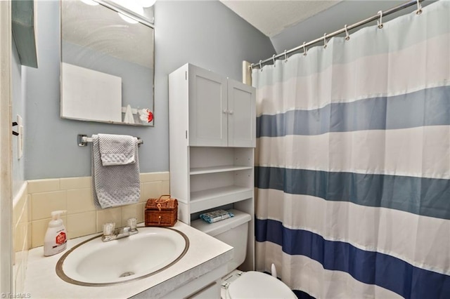 bathroom with a shower with curtain, backsplash, vanity, and toilet