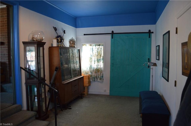 foyer entrance with stairs, carpet, and a barn door