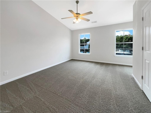 carpeted spare room featuring lofted ceiling, ceiling fan, and a healthy amount of sunlight