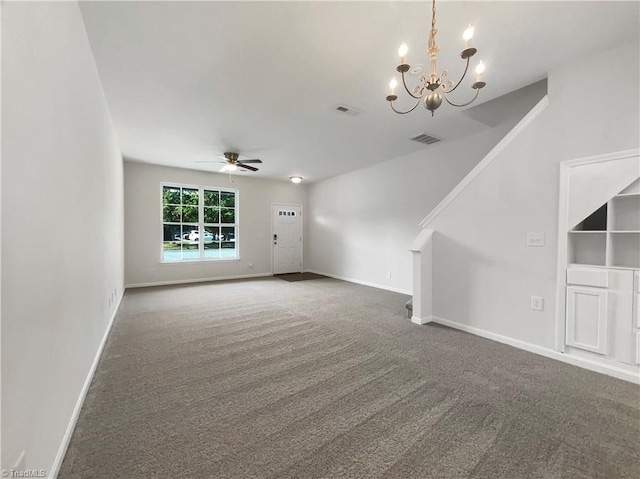 unfurnished living room with ceiling fan with notable chandelier and carpet flooring