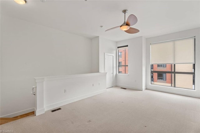 carpeted empty room with baseboards and ceiling fan