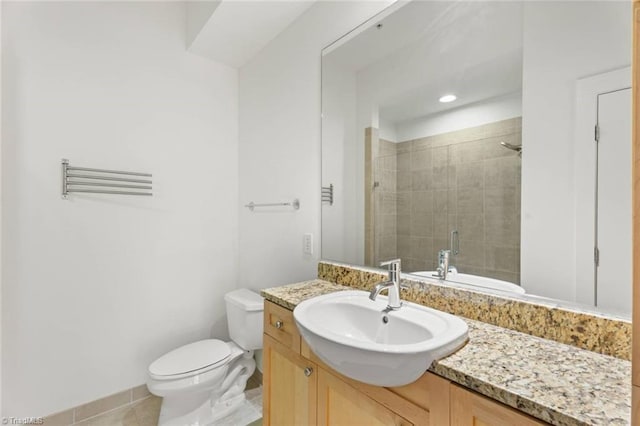 full bath with a tile shower, toilet, vanity, tile patterned flooring, and baseboards