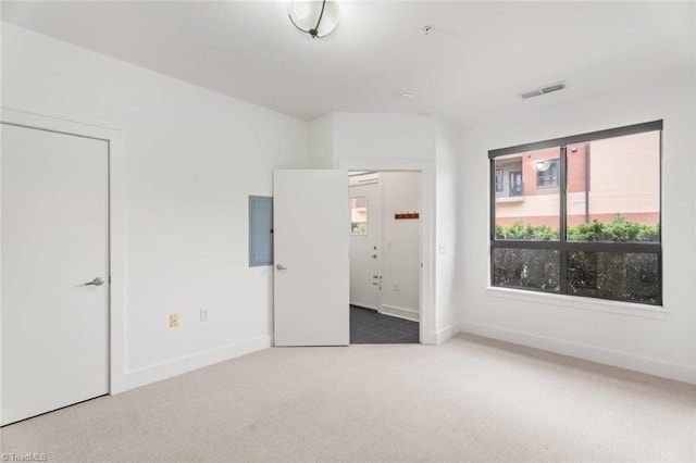 unfurnished bedroom with carpet floors, baseboards, and electric panel