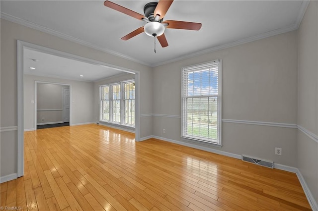 unfurnished room featuring light wood finished floors, visible vents, plenty of natural light, and ornamental molding