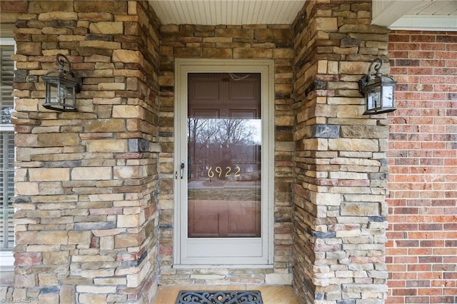 doorway to property with brick siding and stone siding