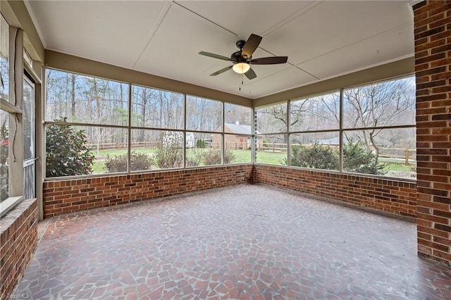 unfurnished sunroom with ceiling fan