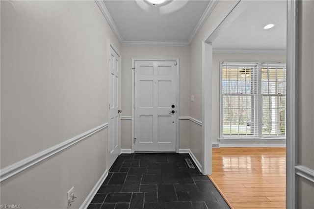 entryway featuring baseboards, crown molding, and stone finish floor