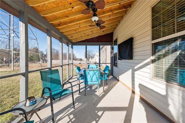 sunroom / solarium with lofted ceiling, wood ceiling, and a ceiling fan