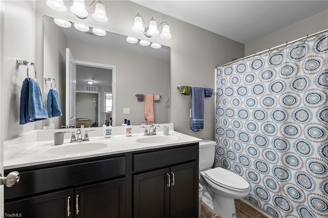 full bath featuring visible vents, a sink, toilet, and double vanity