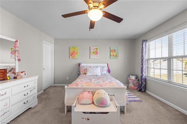 bedroom with a ceiling fan, light colored carpet, and baseboards