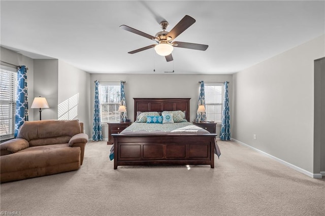 bedroom featuring light carpet, a ceiling fan, and baseboards