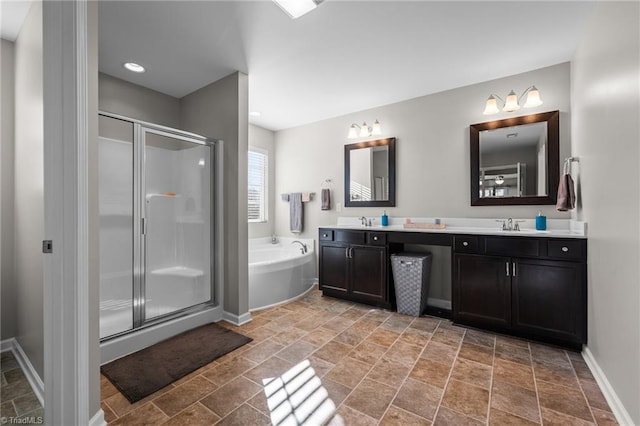 bathroom with double vanity, baseboards, a garden tub, a shower stall, and a sink