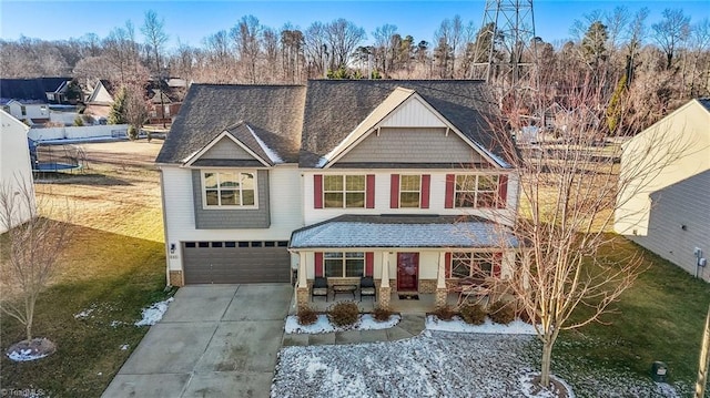 view of front of property with covered porch, roof with shingles, driveway, and an attached garage