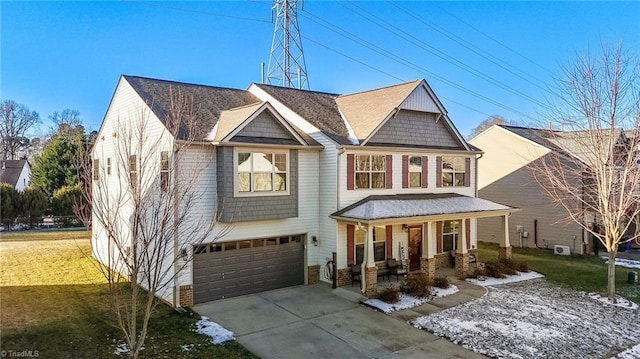 view of front of house featuring a porch, a front yard, driveway, and an attached garage