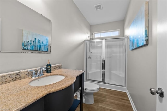 full bathroom featuring toilet, a stall shower, wood finished floors, and visible vents