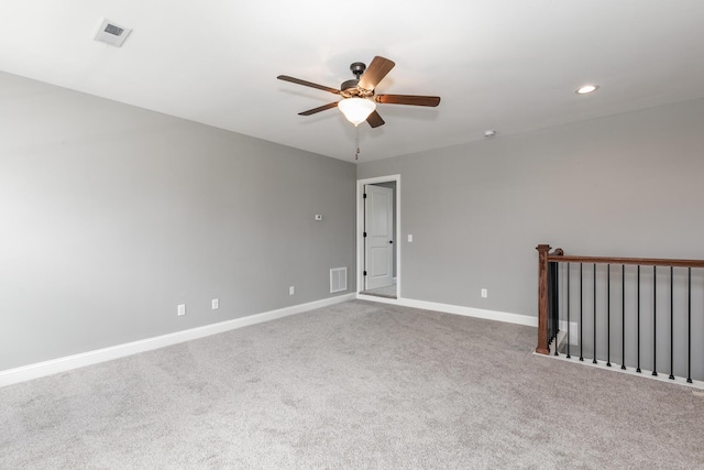 spare room with dark colored carpet and ceiling fan