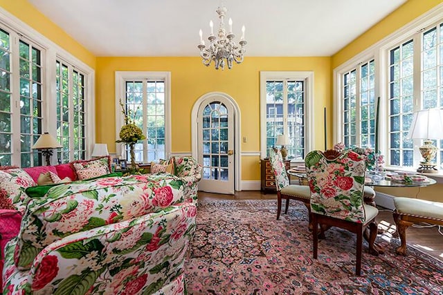 sunroom / solarium featuring a notable chandelier