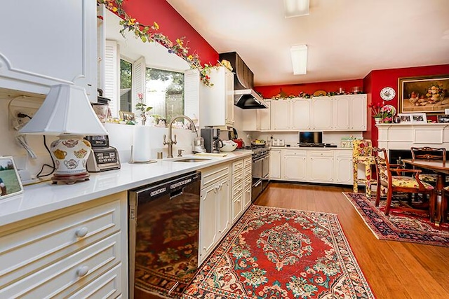 kitchen with stainless steel range oven, sink, white cabinets, black dishwasher, and light wood-type flooring